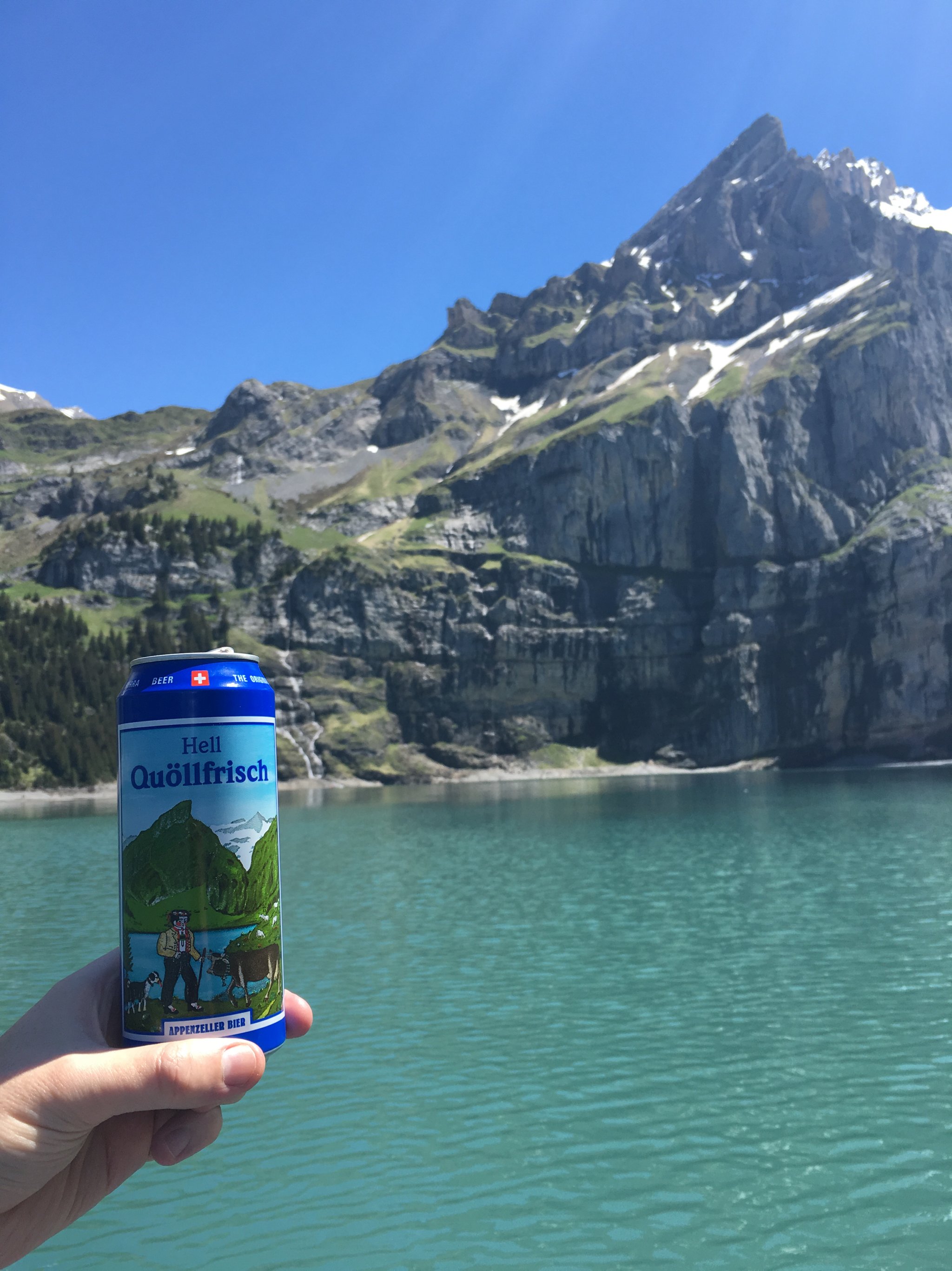 Beer can with a mountain on its label in front of a real mountain that looks exactly like it